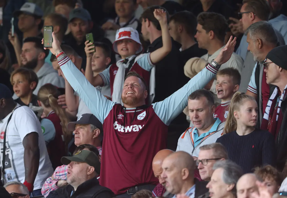 West Ham fans back their side, with one standing with arms outstretched