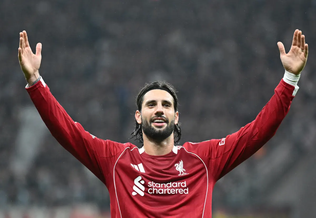 Dominik Szoboszlai stands with arms outstretched after scoring for Liverpool